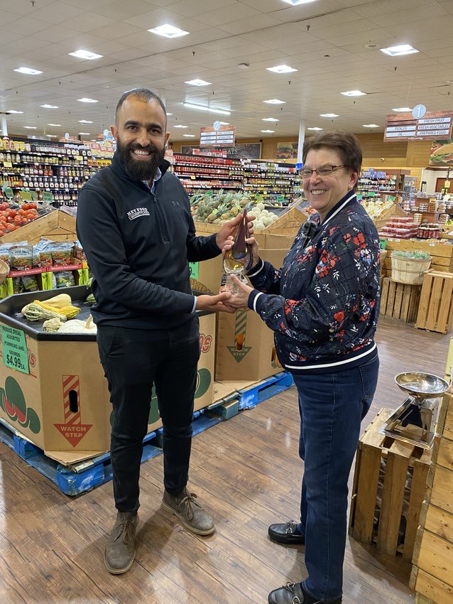 Junior Dabashi, owner of Key Food Marketplace, works with community organization. Here he receives an award from the Greater Pike Community Foundation's Maryanne Monte.